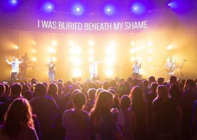 band leading worship with colorful neon stage lighting